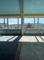 empty room, large windows, concrete floor, white walls, heating radiators