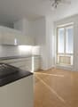 modern kitchen, granite countertop, stainless steel sink, white cabinets, wooden floors, large windows, balcony