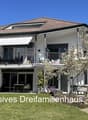 2 story house, white exterior, brown roof, large windows, balcony, garden, trees