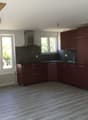 kitchen, maroon cabinets, gray tile backsplash, wooden floor, exhaust hood, stainless steel oven, white radiator