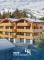 3-story building, wooden exterior, balconies, snowy mountains in the background