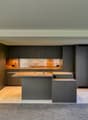 modern kitchen with island, gray cabinets, wooden countertops, built-in appliances, large windows