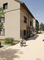 4 story houses, modern design, stone exterior, elevated driveway, front yard with parking, large windows, children playing