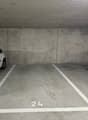 A concrete parking area with two white-marked parking spaces, marked with number '24' and empty