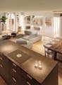open plan living and dining area, large windows, balcony, wooden floor, modern furniture, large painting