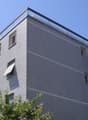4 story building, brick facade, glass windows, glass balcony on top floor