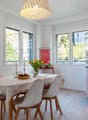 Dining room with a table, chairs, and a kitchen area with an oven and cabinets