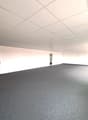 Empty room, white walls, gray floor, two doors, square tiles on ceiling