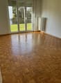 empty room, wooden parquet floor, sliding glass doors, balcony, radiator