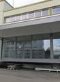 modern building, large glass windows, entrance with stairs, reception area