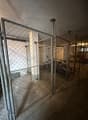 Metallic cage, parked bicycles, concrete floor