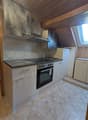 kitchen with white cabinets, tiled floor, granite countertop, gas stove, oven, sink, faucet, wooden ceiling
