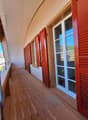 wooden floor, red shutters, glass doors, metal railings, view of the outside