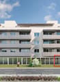 4 story building, white exterior, large windows, balconies, modern design, landscaped area