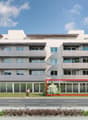 Modern apartment building, 4 floors, large windows, balconies, glass doors, parking lot