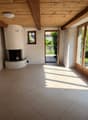 room with fireplace, tile floor, wooden beams, sliding glass doors, white walls, recessed lighting
