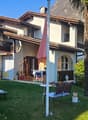 2 story house, brown roof, white walls, balcony, garden, patio, mountain view