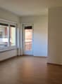 large windows, wooden floor, balcony, white walls, radiator, glass door