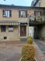 3 story house, beige stone, brown roof, balcony, garden, street lamp, plants
