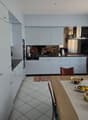 modern kitchen with white cabinets, black countertops, stainless steel appliances, dining table with decorative items