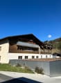 2 story house, brown and white, balcony, green roof, metal fence