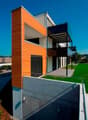 modern 2-story house, wooden wall, concrete wall, large balcony, entrance area, glass doors