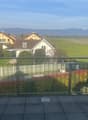 Metal railing, tiled floor, view of houses and mountains