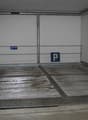 Enclosed parking space with metal racks and an Allianz sign indicating it is a parking area.