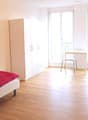 Single bed, white cabinet, desk with chair, balcony with balcony rail, television