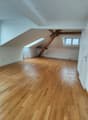 empty room, wooden floor, wooden beams, windows, radiators
