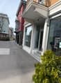 3 story building, brick and white facade, glass door and window, balcony, street sign, parking spot