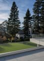 Terrace with glass railing, lush greenery, trees, panoramic view of the mountains and valley