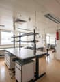laboratory with tables, chairs, cabinets, fire extinguishers, windows, ventilation systems