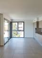 empty room, large windows, sliding glass doors, tiled floor, kitchen area