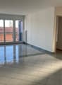 empty room, tiled floor, large windows with balcony, white walls, radiators, door to the right