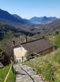 House on a hill, brown roof, yellow handrails, stone steps, mountain view