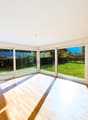large windows, wooden floor, white walls, view of a garden
