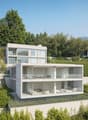 Modern two-story house with large glass windows, balconies, and surrounded by lush greenery