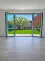 empty room, large glass doors, wooden floor, white walls, garden view