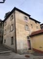 4 story house, tan walls, white shutters, red door, stairs