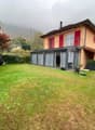 modern detached house, red shutters, brown roof, chimney, glass extension, garden, satellite dish