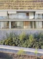 Modern house with two floors, built into a slope, glass walls, raised ground floor, panoramic vineyard views.