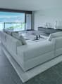 large windows, couch, glass coffee table, shelves, decorative objects, flooring