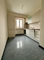 White kitchen with tile floor, white cabinetry, under cabinet lighting, window, stainless steel appliances