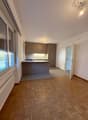 kitchen and living room, wooden floor, grey kitchen cabinets, kitchen island, open to living room, kitchen with sink, large window