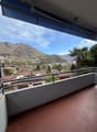 Balcony with tiled floor, metal railing, view of mountains and town