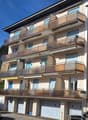 3-story house, beige exterior, multiple balconies, garage entrance, multiple garages
