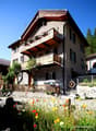 3-story house, wooden balconies, white windows, wooden gate, satellite dish, satellite antenna, garden