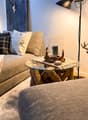 living room with couch, coffee table, desk, lamps, and a deer statue