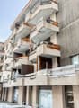 multi-story building, balconies, wood siding, concrete exterior